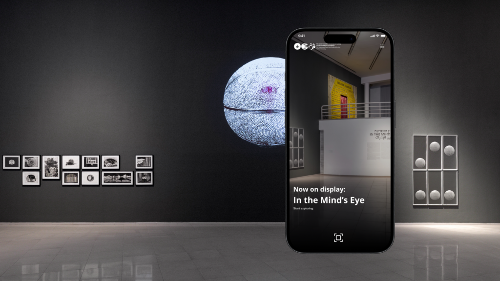 The image shows an art gallery with framed photographs and a large textured sphere on display. A smartphone screen blends into the scene, displaying the exhibition title "In the Mind's Eye" with an invitation to "Start exploring."